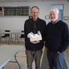 Mr. Schneider, the husband of the winner of one of the Heritage Fair door prizes, a basket of homemade preserves, with FNHA vice-president Fred White.  